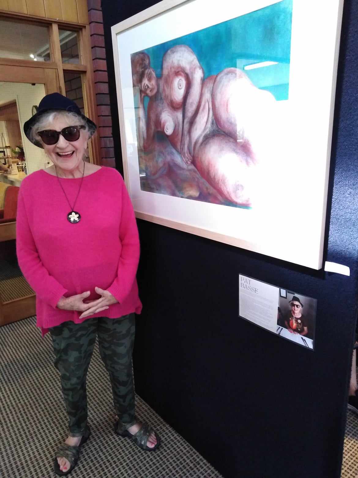 3.	Pat with Guardian 2 1980’s pastel on paper 56 x 71 cm. Pat in her hat, standing in front of one of her nudes – a woman with pendulous breasts reclining.